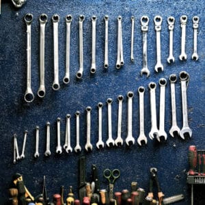 A group of wrenches on a blue wall.